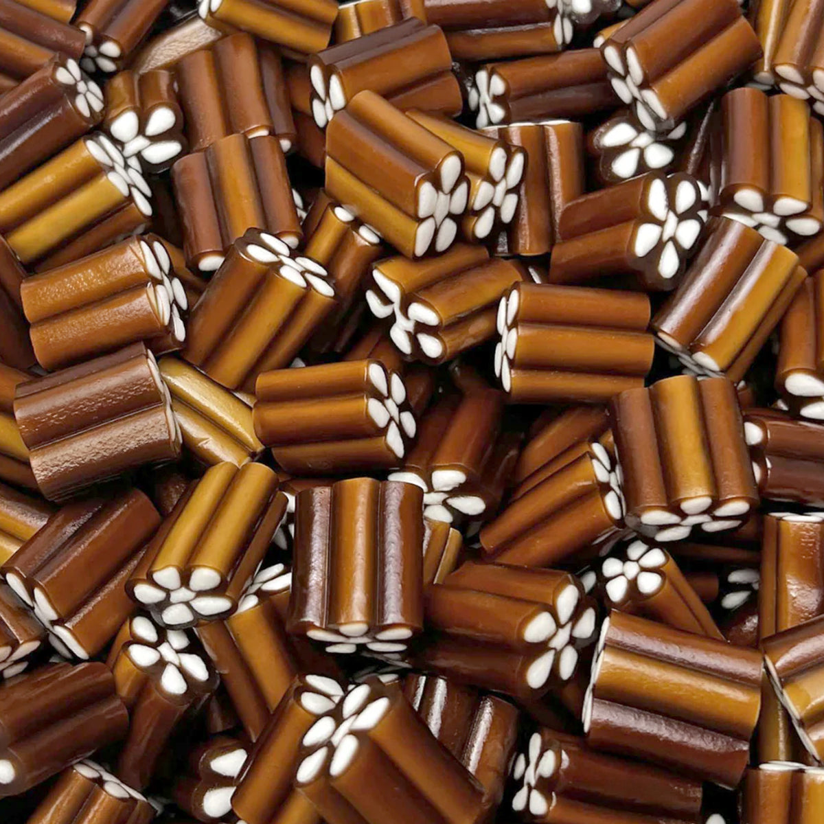 Cola Revolvers — Classic cola candy shaped like a revolver cylinder, finished with a rich vanilla fondant center